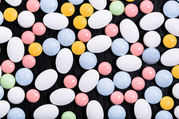 Colorful medicines. Pills, tablets on black background, top view