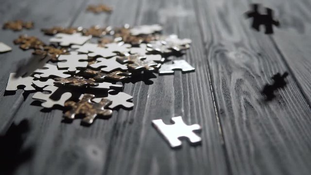 a indoor shot of falling parts of puzzle game on blue wooden table, 100FPS slowmotion