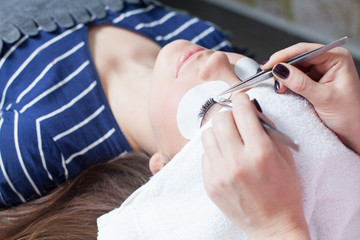 Fototapeta premium beautician making artificial lashes. eyelash extension procedure 