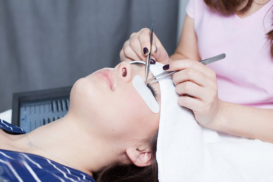 beautician making artificial lashes. eyelash extension procedure 
