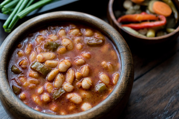 Turkish Kuru Fasulye / Baked Beans in a wooden bowl.