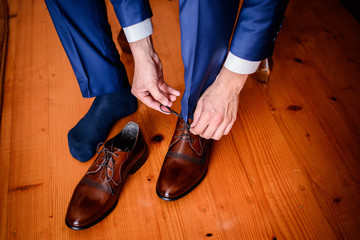 handsome groom getting dressed and preparing for the wedding