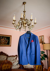 Obraz premium beautiful blue groom's jacket hanging on the chandelier