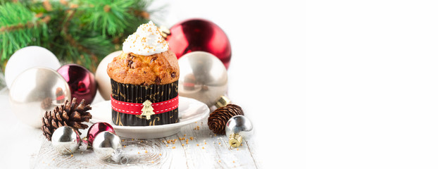 Festive Christmas cupcake decorated with whipped cream on white wooden rustic background. Copy space, long web format. Holiday concept