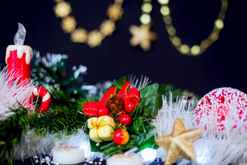 Christmas decoration with green pine, red candle at black background