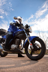 Obraz na płótnie Canvas biker with helmet blue going by a road