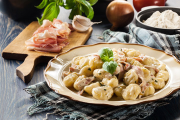 Potato gnocchi, Italian potato dumplings with cheese sauce, ham