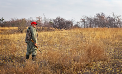 Hunter moving with shotgun looking for prey