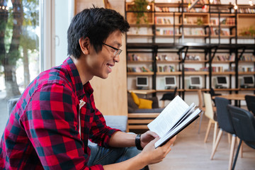 Asian man sitting at the library and reading