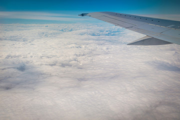 Clouds and sky through window of an aircraft.