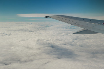 Fototapeta na wymiar Clouds and sky through window of an aircraft.