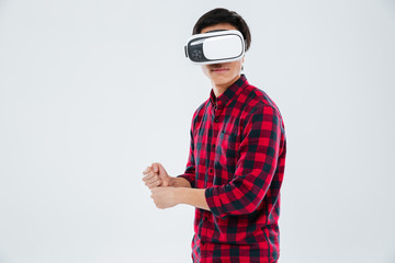 Man wearing virtual reality device and holding imagine tennis racket