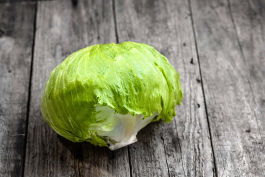 Iceberg lettuce, green vegetable on wooden rustic background