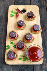 Sandwiches with black rye bread in the shape of a heart, blood sausage (Morcillo) and pieces of...