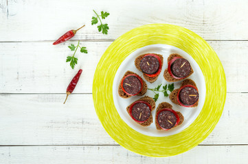 Sandwiches with black rye bread in the shape of a heart, blood sausage (Morcillo) and pieces of...