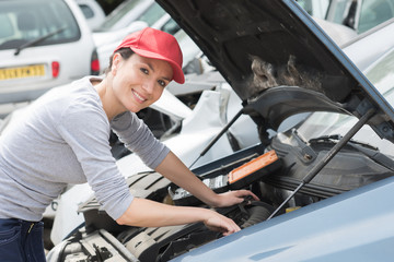portrait of confident female mechanic fixing car