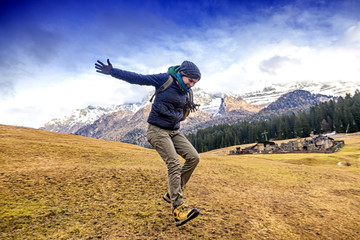 happy girl jumping on the background traveler Alps. Active holid