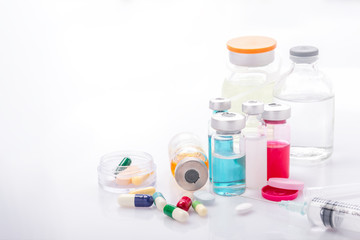 Fototapeta na wymiar Glass Medicine Vials with syringe pills capsule on white table