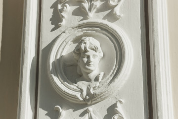 The bas-relief with the image of a young woman on a facade