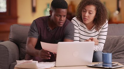 African American couple pays their bills on their laptop - Powered by Adobe