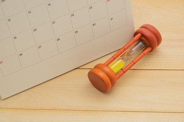 sandglass and calender date on wooden bacground
