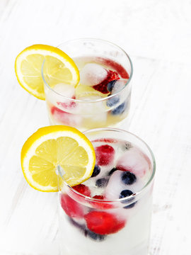 mineral water with fruit frozen in ice cubes