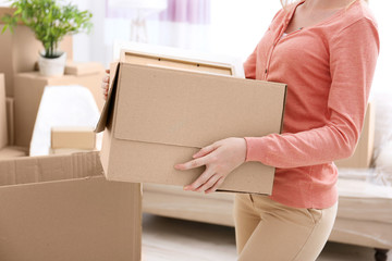 House moving concept. Woman holding cardboard box, closeup