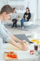 a young man making a pastry for friends