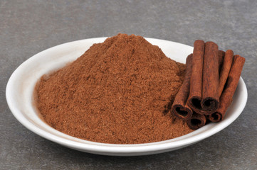 Coupelle de cannelle en poudre avec des bâtons de cannelle