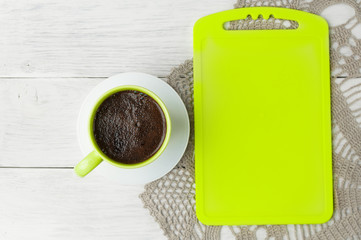 Green cup coffee on office wooden table