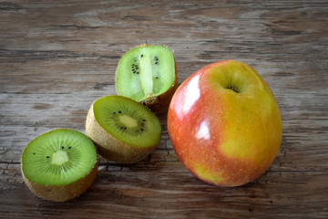 Apple and kiwi isolated on rustic black background. Organic food.