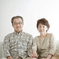 ソファーで微笑むシニア夫婦
