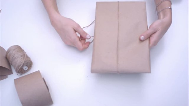 Woman wrapping present with jute