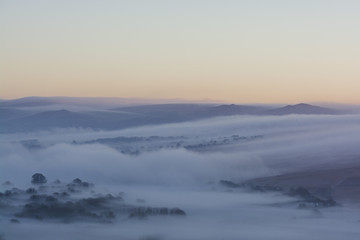 sunrise over Dartmoor with mist rolling over hills, Devon, UK