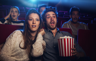 Fototapeta premium Young couple at the cinema watching an horror movie