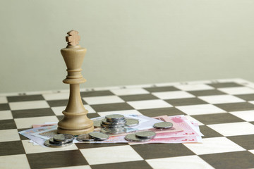 The chess king on a chessboard and money