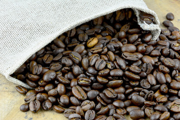 Kaffeebohnen mit Jutesack am Holztisch 