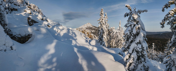 idillic mountain winter landscape with snow drifts and snowcovered trees