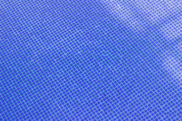 Blue tiles of swimming pool can be used as background