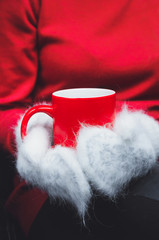 girl in red sweater and white mittens holding hot cup