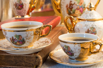 Retro porcelain coffee cups with hot espresso and vintage dishwa