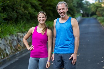 Obraz premium Athletic couple standing on road after jogging