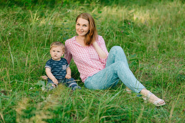 Fototapeta premium Happy mom with her little son in summer park