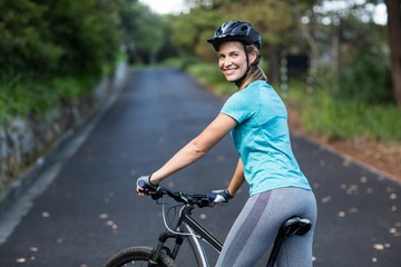 Woman standing with mountain bike on the open road