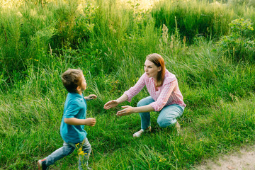 Fototapeta premium Happy mom with her little son in summer park