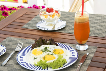 Breakfast on the wooden table: sunny side up eggs and cream chee