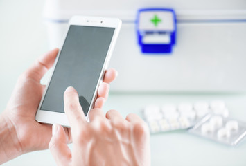 Woman’s hands using smartphone for buying drugs