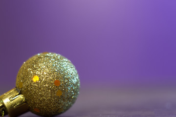 Gold Christmas ball on a purple background