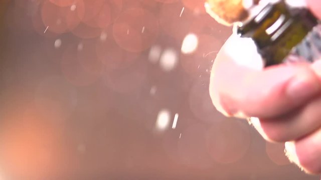 Champagne. Opening champagne bottle closeup. Sparkling Wine over Holiday Bokeh Blinking Background.   Slow motion 240 fps. 