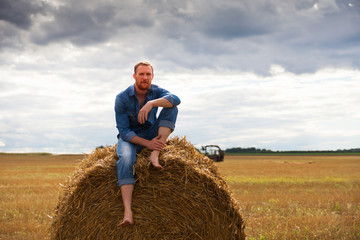 Naklejka na ściany i meble bearded man on field at harvest time.